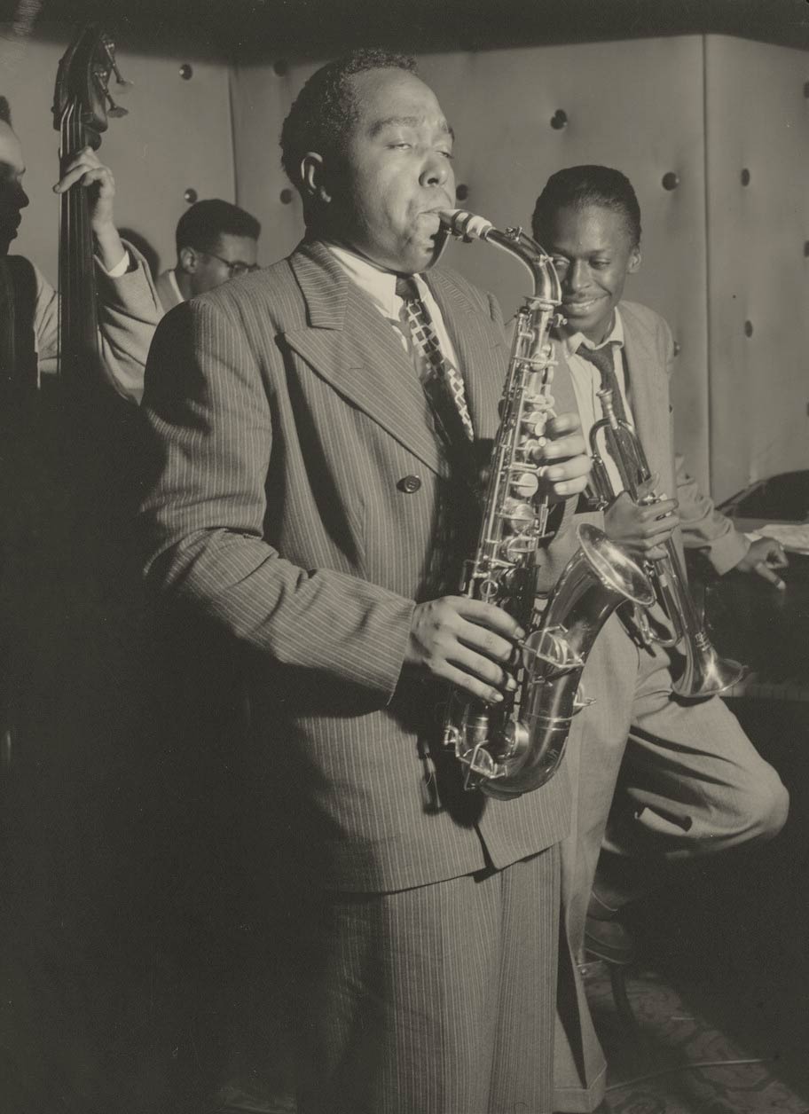a 1947 photo of Charlie Parker playing the saxophone with a band